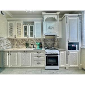 a kitchen with white cabinets and a stove top oven at Classic Apartment in Tashkent