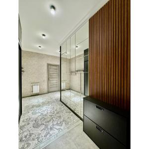 a bathroom with a large mirror and a wooden wall at Classic Apartment in Tashkent +19 photos