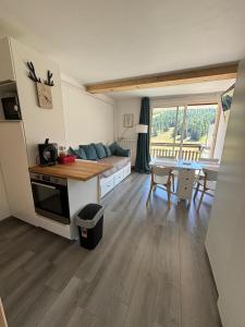 ein Wohnzimmer mit Couch und Tisch in der Unterkunft STUDIO 4 PERS SUD - L'Etoile des Rennes - Superdevoluy PIED DES PISTES in Le Dévoluy