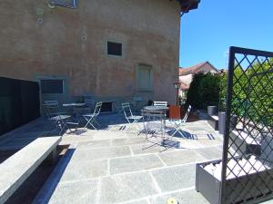 a patio with chairs and tables and a building at Ortacolorhome BlueHome-Boleto in Madonna del Sasso +11 photos