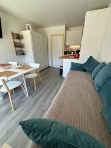 a living room with a bed and a table at STUDIO 4 PERS SUD - L'Etoile des Rennes - Superdevoluy PIED DES PISTES in Le Dévoluy +4 photos
