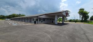 拜伦Red Roof Inn Byron的加油站,停在停车场的汽车