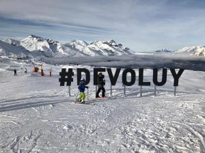 two people on skis in the snow next to a sign at STUDIO 4 PERS SUD - L'Etoile des Rennes - Superdevoluy PIED DES PISTES in Le Dévoluy