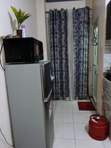 a microwave on top of a refrigerator in a kitchen at Cosy studio Yellow House bamburi in Mombasa