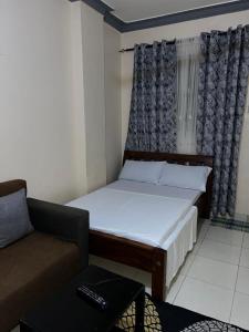 a small bedroom with a bed and a couch at Cosy studio Yellow House bamburi in Mombasa
