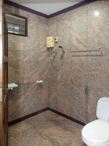 uma casa de banho com chuveiro e WC em Pattaya Garden Apartments Boutique Hotel em South Pattaya