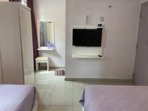 a bedroom with a flat screen tv on a wall at Lavender Riverside Hotel in Malacca