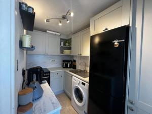 kuchnia z czarną lodówką i zmywarką do naczyń w obiekcie Boutique 2 storey home nr centre w mieście Chipping Norton