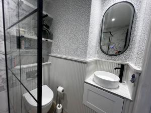 W łazience znajduje się lustro, toaleta i umywalka. w obiekcie Boutique 2 storey home nr centre w mieście Chipping Norton +9 zdjęć