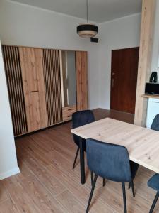 a dining room with a wooden table and chairs at Apartament zamkowa 1 in Żywiec +4 photos