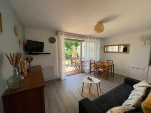 Μια τηλεόραση ή/και κέντρο ψυχαγωγίας στο Appartement avec chambre, terrasse et jardinet proche plage, forêt pins, piste cyclable, lac