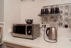 a microwave sitting on a counter in a kitchen at 09ApartKZ in Karagandy