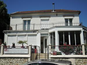 a white house with a car parked in front of it at Les Pingouins de la Marne 2 in Le Perreux-Sur-Marne