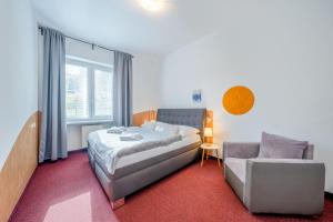a bedroom with a bed and a couch and a chair at Na vyhliadke in Starý Smokovec +38 photos