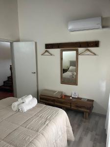une chambre avec un lit et un miroir dans l'établissement Lo de Ana, à San Antonio de Areco
