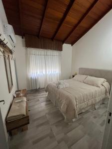 une chambre avec un grand lit et un plafond en bois dans l'établissement Lo de Ana, à San Antonio de Areco