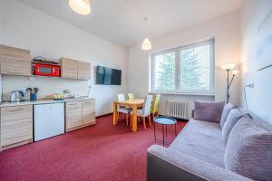 a living room with a couch and a kitchen at Na vyhliadke in Starý Smokovec