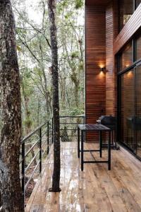 a wooden deck with a table and a tree at Lujosa casa en el Bosque cerca de la ciudad in San Cristóbal de Las Casas