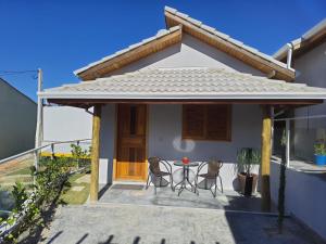 a house with a patio with two chairs and a table at Pousada do Barao in Cunha