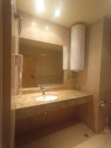 une salle de bains avec un lavabo et un miroir dans l'établissement Central Avenue apartments, à Sunny Beach