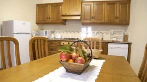 a basket of fruit on a table in a kitchen at Quinta Da Mata in Sobral