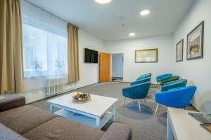 a living room with a couch and blue chairs at Na vyhliadke in Starý Smokovec