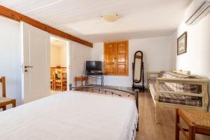 a bedroom with a white bed and a couch at Votsalo Spetses in Spetses