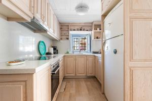 a kitchen with wooden cabinets and a white refrigerator at Votsalo Spetses in Spetses