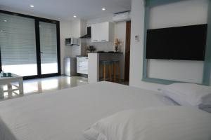 Un dormitorio con una cama grande y un televisor de pantalla plana. en Le grand horizon, en Sfax