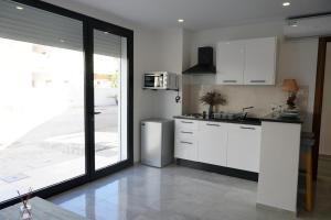 Una cocina con gabinetes blancos y un refrigerador de acero inoxidable. en Le grand horizon, en Sfax 2 fotos más
