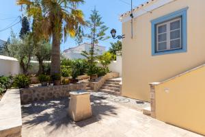 a house with a palm tree and stairs at Votsalo Spetses in Spetses