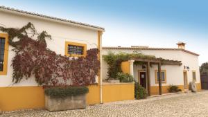 une maison avec de la peinture jaune et blanche dans l'établissement Quinta Da Mata, à Sobral