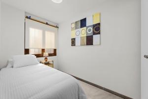 アレシーフェにあるCasahost Casa Albaの白いベッドルーム(ベッド1台、絵画付)