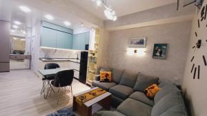 a living room with a couch and a kitchen at Avenue Star in Tbilisi City