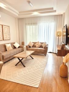 a living room with a couch and a coffee table at The Apparte Salalah in Ţāqah
