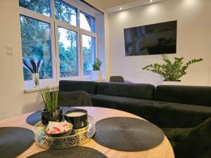 a living room with a table and a couch at Wyjątkowy Apartament w Miliczu in Milicz