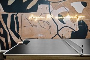 a ping pong table in front of a wall with graffiti at Rock Climbing Wall Pool& Mini Golf Game Room Mural in Peoria