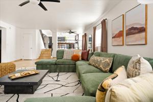 a living room with a green couch and a table at Rock Climbing Wall Pool& Mini Golf Game Room Mural in Peoria