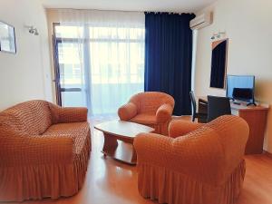un salon avec deux chaises et une table dans l'établissement Central Avenue apartments, à Sunny Beach