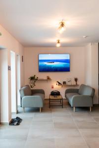 een woonkamer met twee banken en een flatscreen-tv bij Hidden Chalet in Tarcău-Gheuca