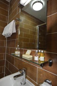 een badkamer met een wastafel, een spiegel en een wastafel bij Lucky 8 Hotel in Ilford