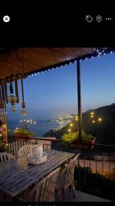 a table on a balcony with a view of the city at THE SECRET GARDEN in Forza dʼAgro