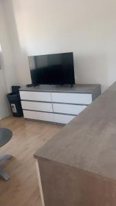 einen Flachbild-TV auf einer Kommode in der Unterkunft T2 tout équipé pour 4 personnes en bord de mer in Saint-Cyprien