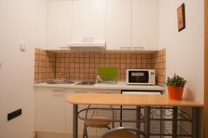 a small kitchen with a table and a microwave at Guest House Nokturno in Zagreb