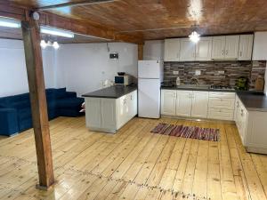 a kitchen with white cabinets and a refrigerator at Cabana de lângă Vale in Budureasa +12 photos