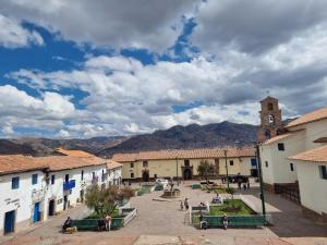 un grupo de personas caminando por una ciudad con una torre del reloj en Departamentos Cusco, en Cusco