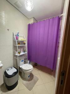 a bathroom with a purple shower curtain and a toilet at Appartement Tanger in Tangier +25 photos