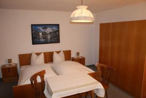 ein Schlafzimmer mit einem Bett, einem Tisch und einem Kronleuchter in der Unterkunft Ferienhaus Waldesruh in Sautens