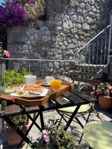 une table en bois avec une assiette de nourriture et du jus d'orange dans l'établissement Villa Valentina Suite, à Massa Lubrense 13 autres photos