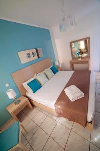 a bedroom with a large bed and a blue wall at Minos Apartments & Studios in Sitia